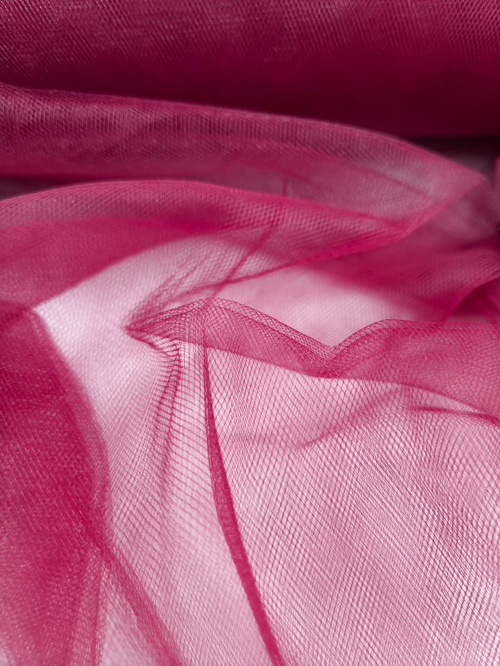 Close-up of Soft Tulle - Emboldened - 150cm by Super Cheap Fabrics, featuring sheer pink layers with delicate textures and a subtle mesh—ideal for costumes or elegant bridal veils.