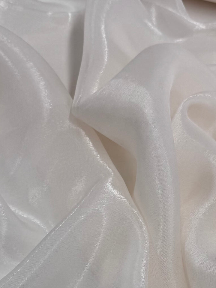 The Blended Silk Mousseline - Bridal Blush from Super Cheap Fabrics, spans 147cm, features soft, white silk that drapes beautifully to create gentle lines with a subtle sheen, capturing the essence of delicate elegance with its smooth and lustrous texture.