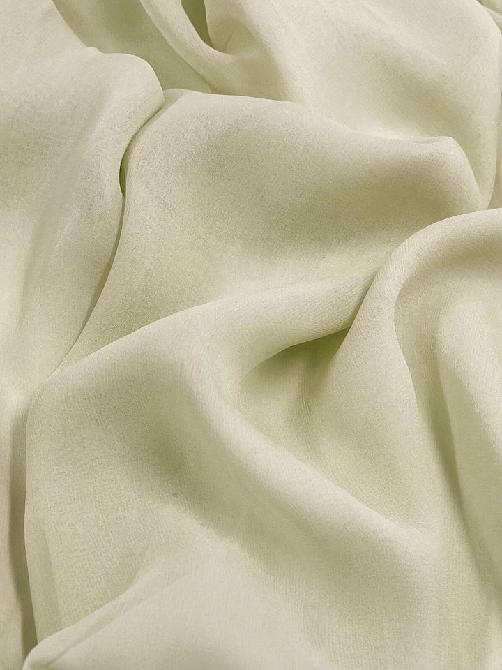 A close-up of Super Cheap Fabrics' Silk Georgette in Champagne, 135cm wide, showcases its soft, light beige hue with gentle folds and draping. The texture appears smooth and lightweight, creating an elegant and airy appearance.