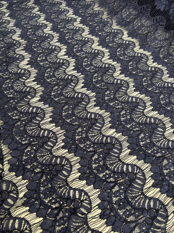 Evening Lace – Crown Of Navy by Super Cheap Fabrics features intricate black floral lace over a light beige base. At 135cm wide, this striking, lightweight fabric creates bold contrast between the dark lace and pale background.