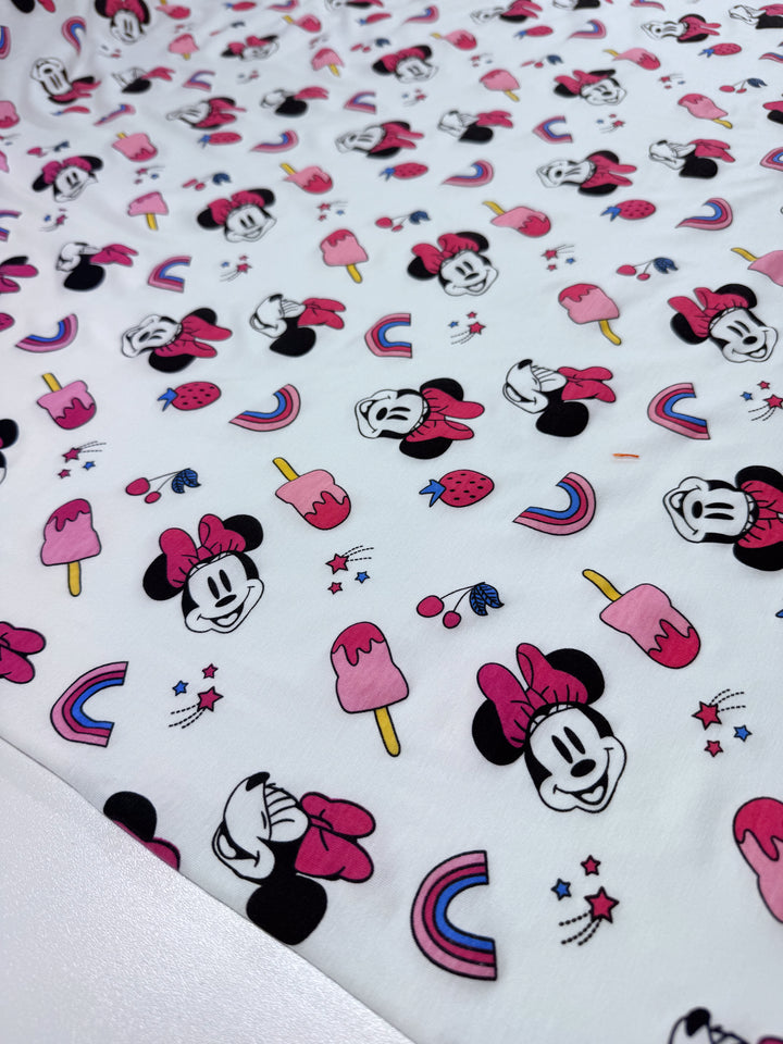 The Super Cheap Fabrics Printed Jersey - Minni Summer (150cm) features a medium-weight fabric with cartoon mouse faces, pink bows, ice pops, strawberries, cherries, and rainbows on white. It offers a delightful two-way stretch for comfortable wear.