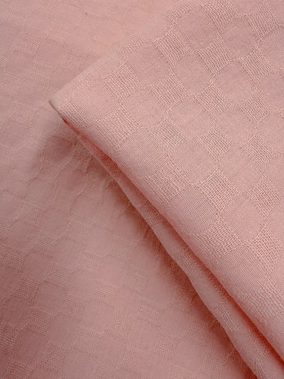 A close-up of Super Cheap Fabrics' Textured Cotton - Chalk Pink (145cm), a soft, lightweight cotton fabric with a subtle grid-like texture—slightly sheer and perfect for summer pants.