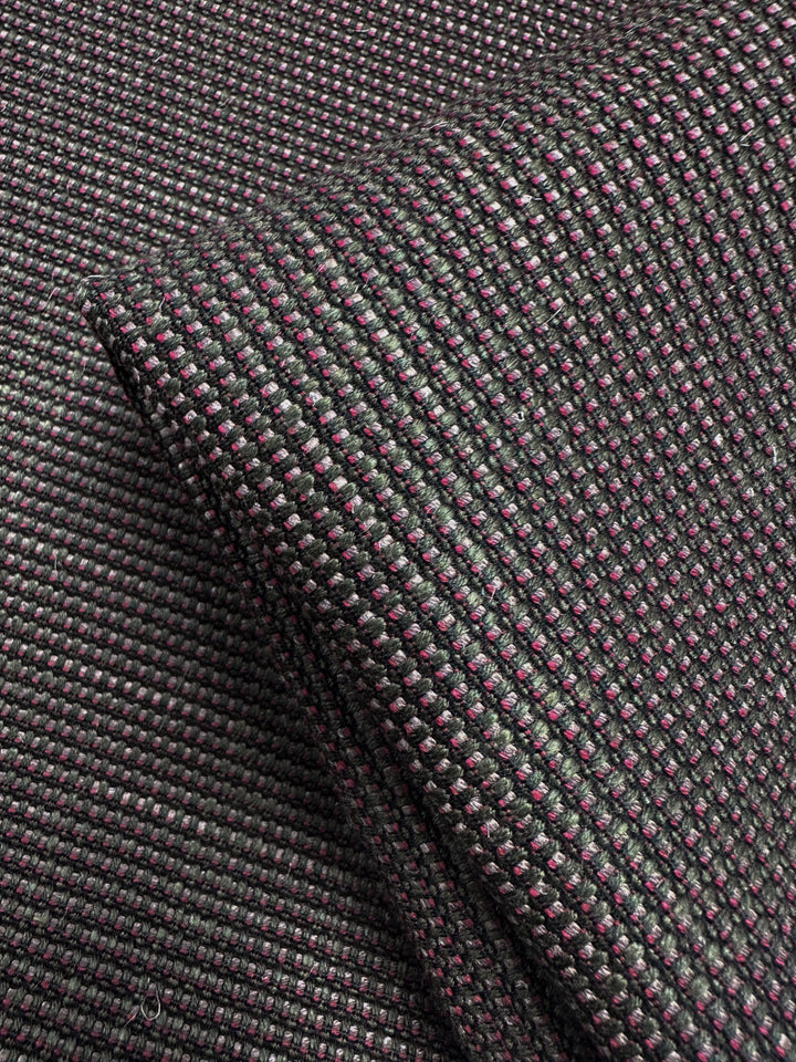 Close-up of Grid Upholstery - Yari 125 (147cm) by Super Cheap Fabrics, showing folded, heavyweight fabric with a woven black and dark purple grid pattern, textured surface, and subtle sheen.
