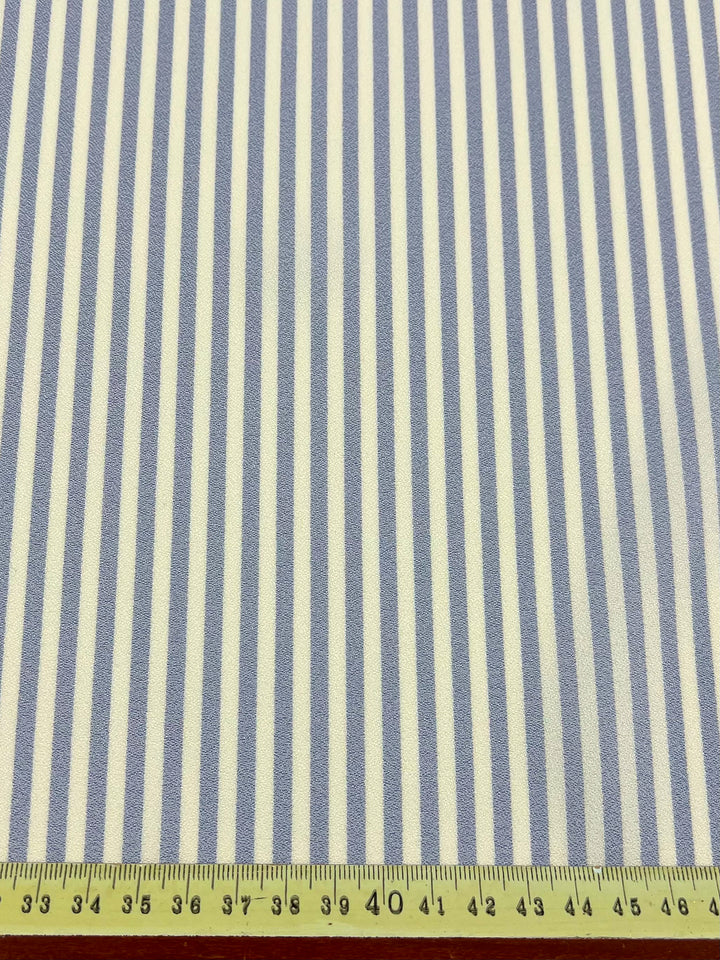 Striped Crepe - Pale Iris by Super Cheap Fabrics is a lightweight fabric with evenly spaced 1 cm vertical blue and white stripes, ideal for eveningwear or tailored shirts. Fabric width: 150cm.