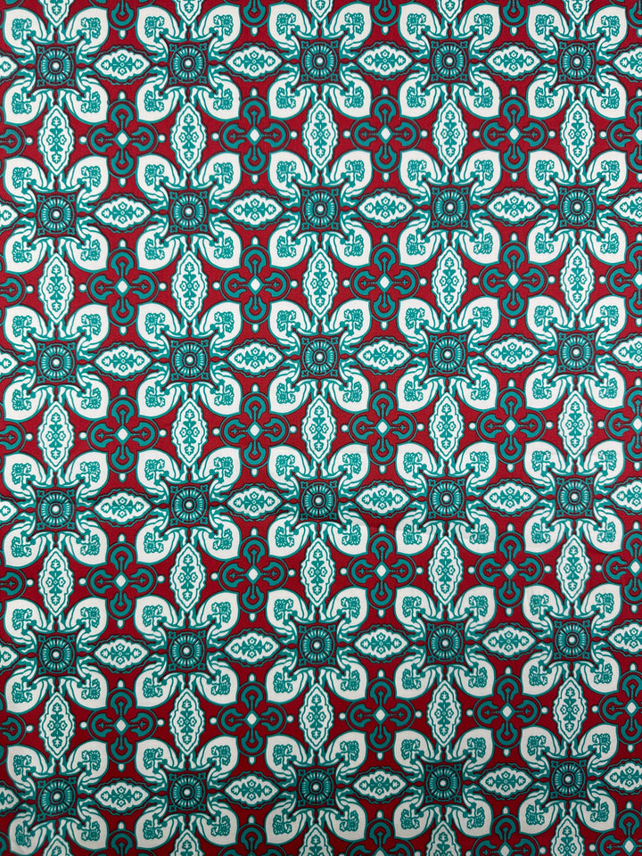 The Cotton Sateen - Mural - 150cm from Super Cheap Fabrics features a teal and white geometric cross motif on dark red, perfect for adding a vibrant decorative touch to your home décor.