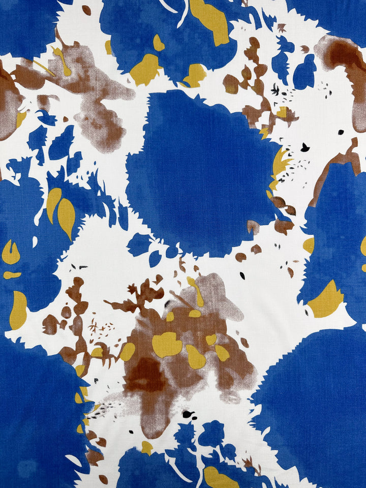 Bamboo Rayon - Splash - 150cm by Super Cheap Fabrics features large blue shapes, brown and yellow patches, and black dots on white—ideal sewing material for dynamic lightweight fabric designs.