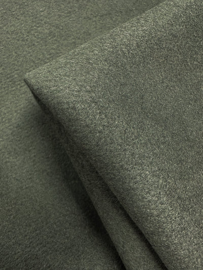 Close-up of overlapping pieces of Super Cheap Fabrics' Wool Cashmere in Agave Green (150cm), highlighting its luxurious softness and smooth, slightly fuzzy texture.