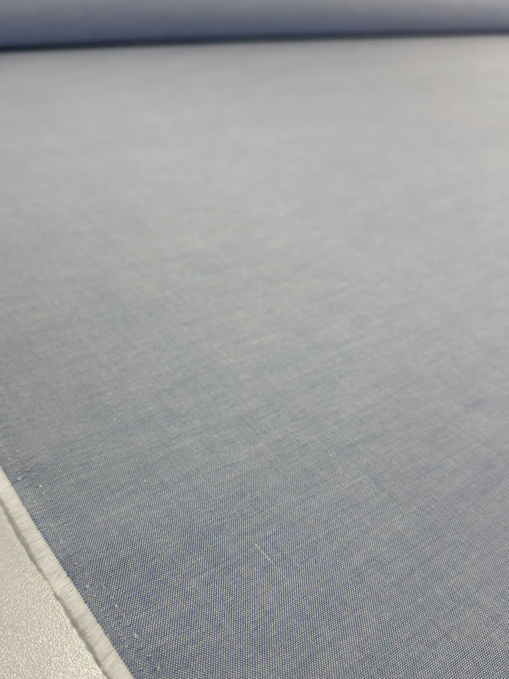 A close-up of Super Cheap Fabrics’ Oxford Cotton - Little Boy Blue (146cm), showcasing its smooth, finely woven texture spread out on a flat surface.