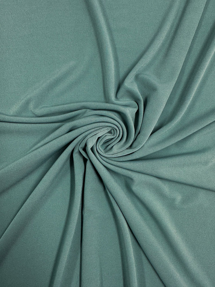 Super Cheap Fabrics’ ITY Knit - Arctic - 150cm is a light teal, medium-weight fabric with a smooth texture, soft drape, gentle sheen under light, and subtle stretch for comfort—perfect for projects needing elegant spirals and folds.