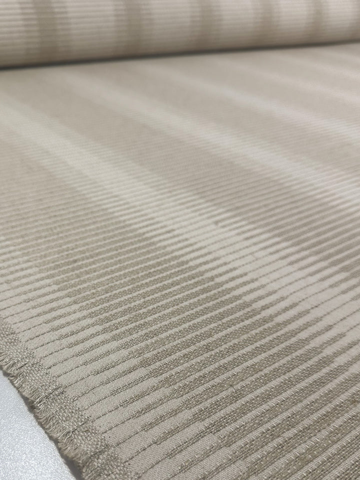 A close-up of Melmoth Stripe Nat, a beige textured jacquard upholstery by Super Cheap Fabrics, features ribbed horizontal lines—ideal for high-end drapery or upholstery. Fabric width: 142cm.
