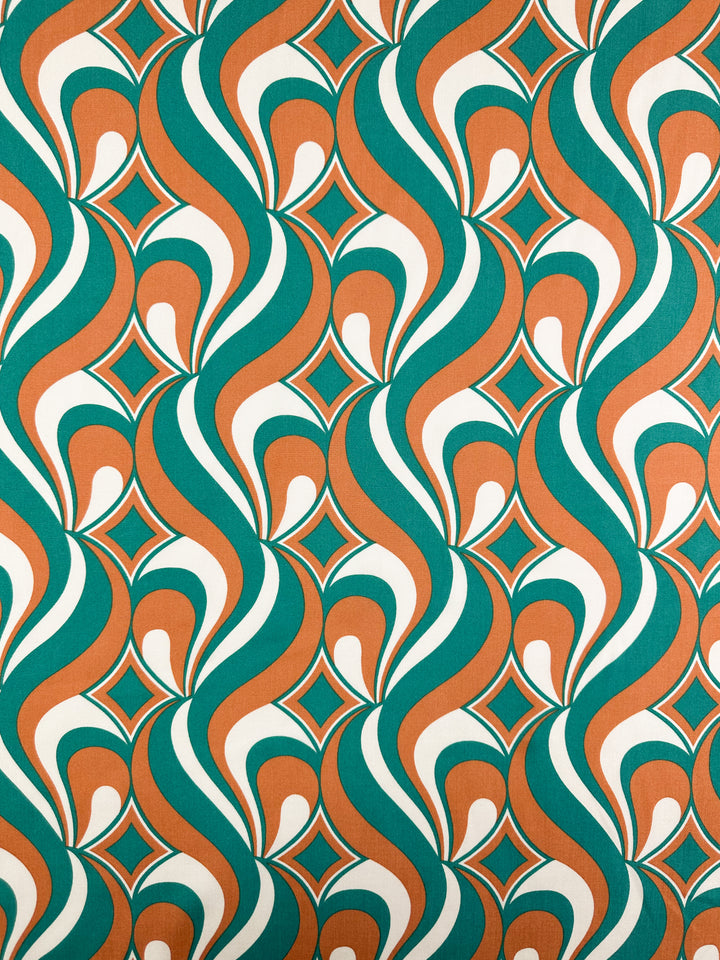 Designer Rayon - Retro Pulse - 145cm by Super Cheap Fabrics features a vibrant 1970s-inspired wavy retro pattern in teal, orange, and white with diamond shapes, offering a symmetrical, dynamic look.