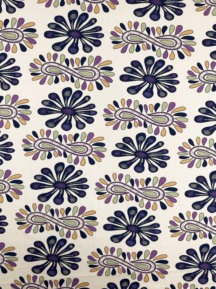 Super Cheap Fabrics Designer Rayon - Lilac Tempo (145cm) features a patterned rayon with abstract floral and paisley motifs in dark blue, purple, yellow, and beige on a light cream background.