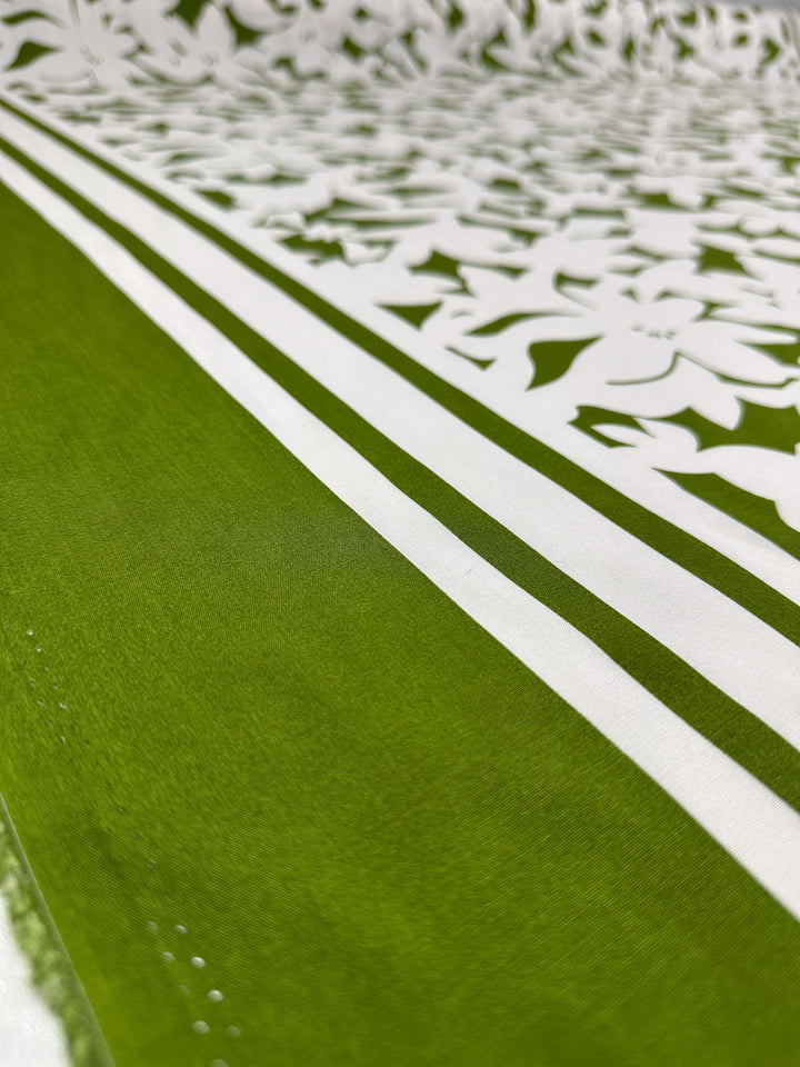 Close-up of Super Cheap Fabrics' Designer Rayon - Olive Fade (145cm), featuring bold green and white stripes with floral cut-out designs, where the vibrant pattern subtly fades into the background.