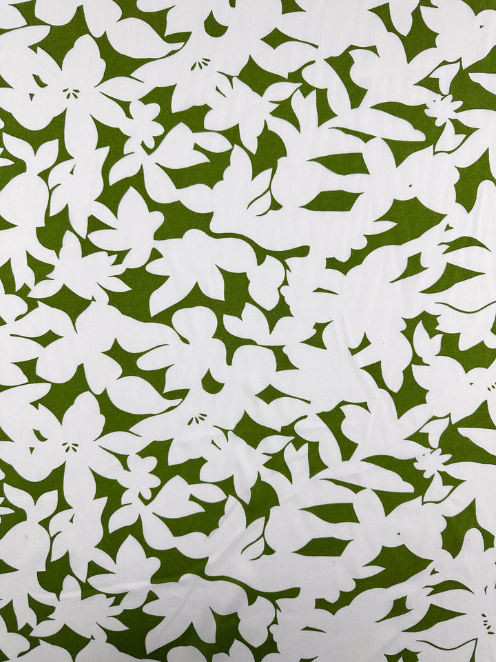 Designer Rayon - Olive Fade by Super Cheap Fabrics is a 145cm wide white rayon fabric with an abstract nature-inspired pattern of green leaf and flower silhouettes, offering a high-contrast, vibrant look.