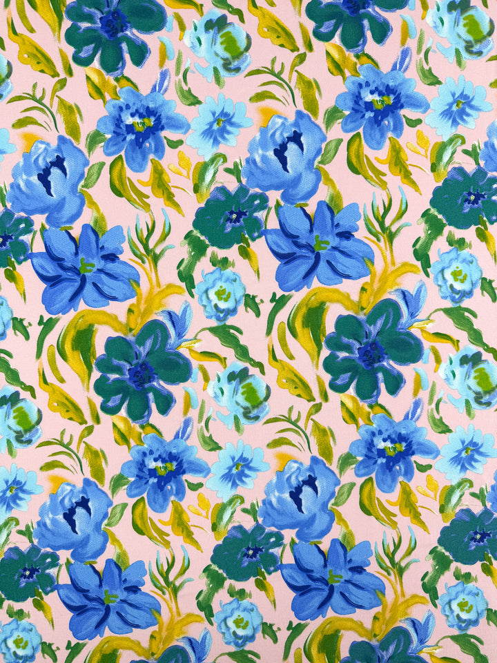 A seamless designer fabric with large blue and teal flowers, green and yellow leaves on pale peach in a watercolor style—perfect for stylish projects. Designer Rayon - Bluebell Blush - 145cm by Super Cheap Fabrics.