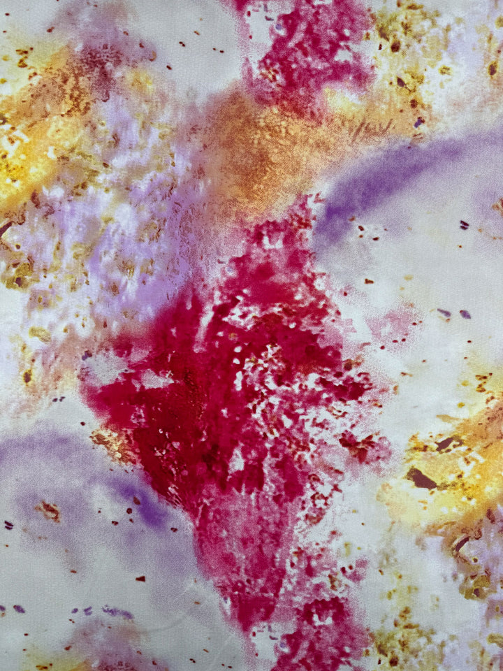 Designer Rayon – Aurora Bloom (143cm) by Super Cheap Fabrics features dynamic splashes of red, purple, and yellow on white, blending in a vibrant watercolor-like pattern with textured areas inspired by designer fabric.