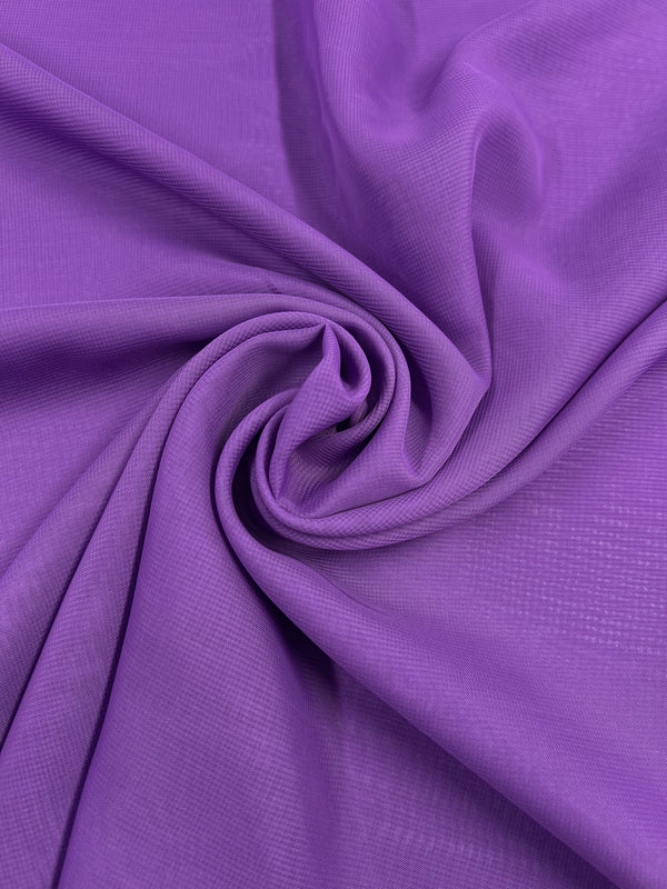 A close-up of a swirling fold of Super Cheap Fabrics' Hi-Multi Chiffon in African Violet, highlighting its smooth texture and vibrant color. The 150cm sheer fabric is gathered at the center, forming a circular pattern with gentle shadows.