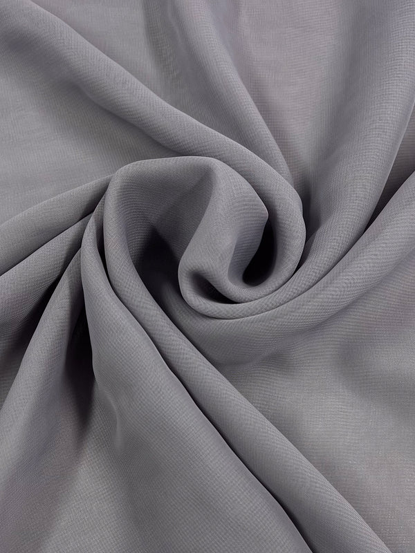 A close-up image of Super Cheap Fabrics' Hi-Multi Chiffon in the Lunar shade, expertly folded into a central spiral pattern. The fabric showcases a smooth texture with subtle, fine lines running across the surface, giving it a lightweight and flowing appearance.