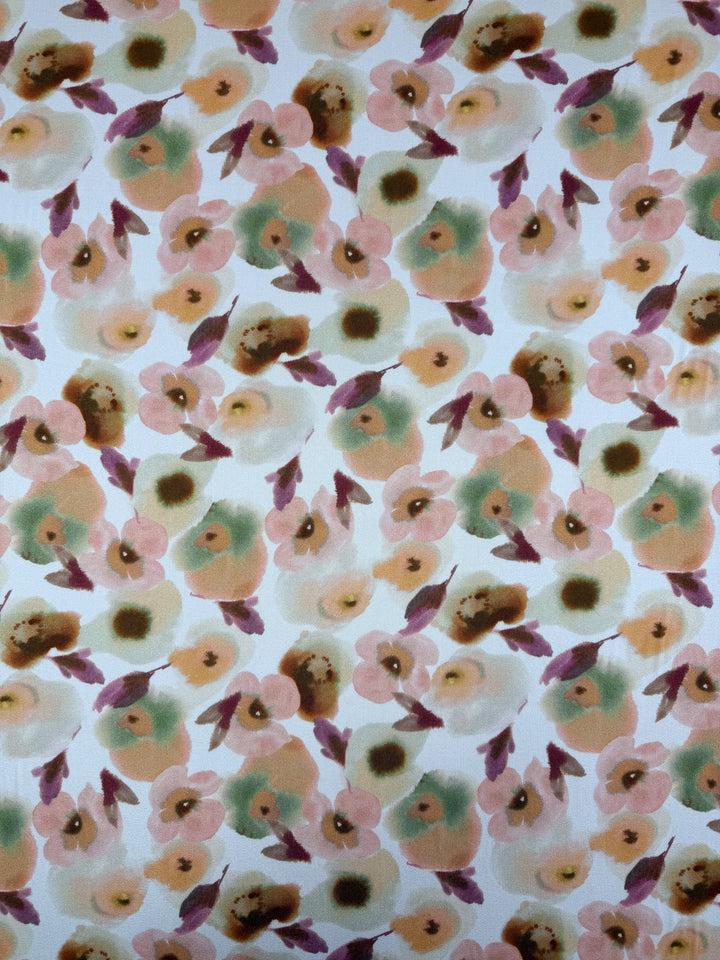 Super Cheap Fabrics’ Mercerised Rayon - Blushed Camellia (150cm) is a lightweight, stylish rayon with abstract peach, pink, green, and brown floral patterns on white, offering both comfort and a unique watercolor look.