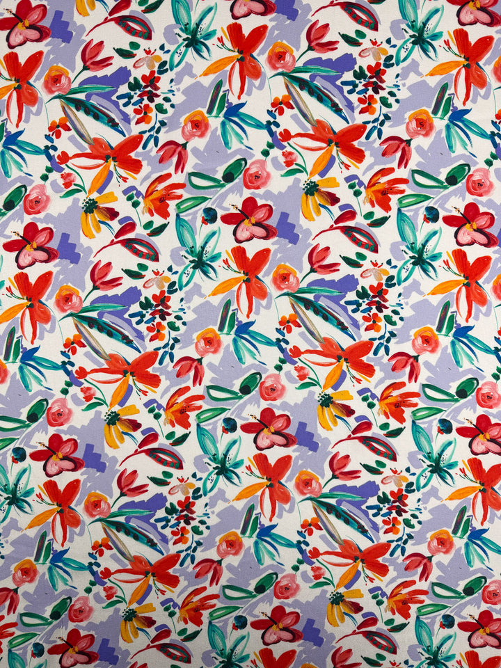 Super Cheap Fabrics’ Mercerised Rayon - Tropical Brushstroke (150cm) features a vibrant floral print with red, orange, pink, and yellow flowers plus green leaves in a loose watercolor style on lightweight fabric with a crisp white background.