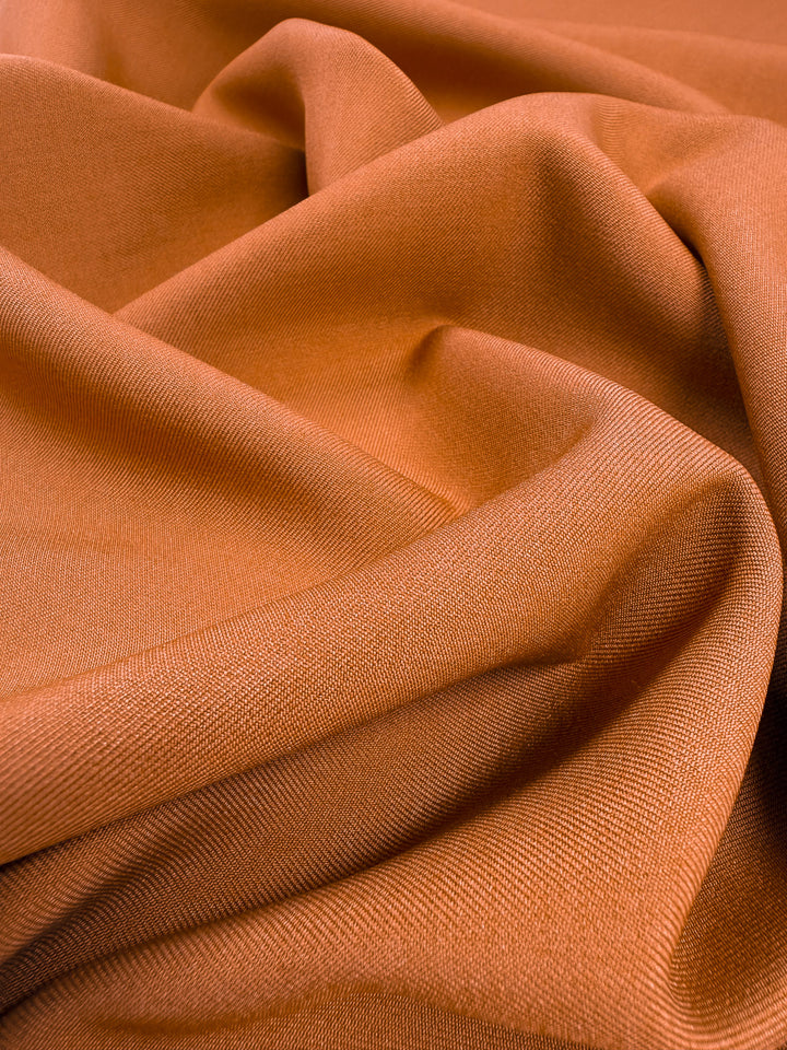 A close-up of Super Cheap Fabrics' Liquid Twill in Tomato Cream (150cm), showcasing the fabric’s soft drape, gentle folds, and subtle woven texture.
