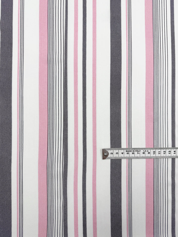 Super Cheap Fabrics' Printed Rayon - Candy Noir Stripe - 140cm features lightweight rayon with vertical pink, black, and white stripes; a measuring tape at the corner shows a width of about 18cm.