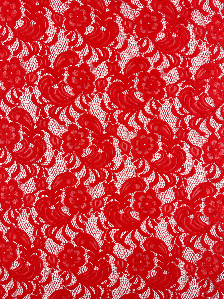 Designer Lace - Scarlet by Super Cheap Fabrics features an intricate floral pattern, ideal for evening dresses. The lace boasts various flower and leaf sizes on a white background, enhancing its elegance and craftsmanship. Available in 145cm width.