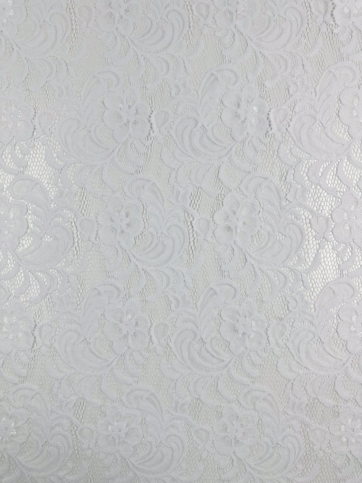 The close-up of Super Cheap Fabrics' Designer Lace in White - 145cm reveals a floral pattern with swirls and mesh, creating a textured and delicate look ideal for evening dresses.